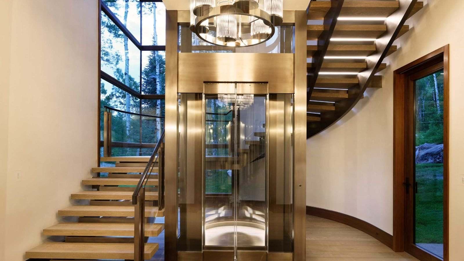 Glass elevator serving all floors and floating staircase with integrated lighting