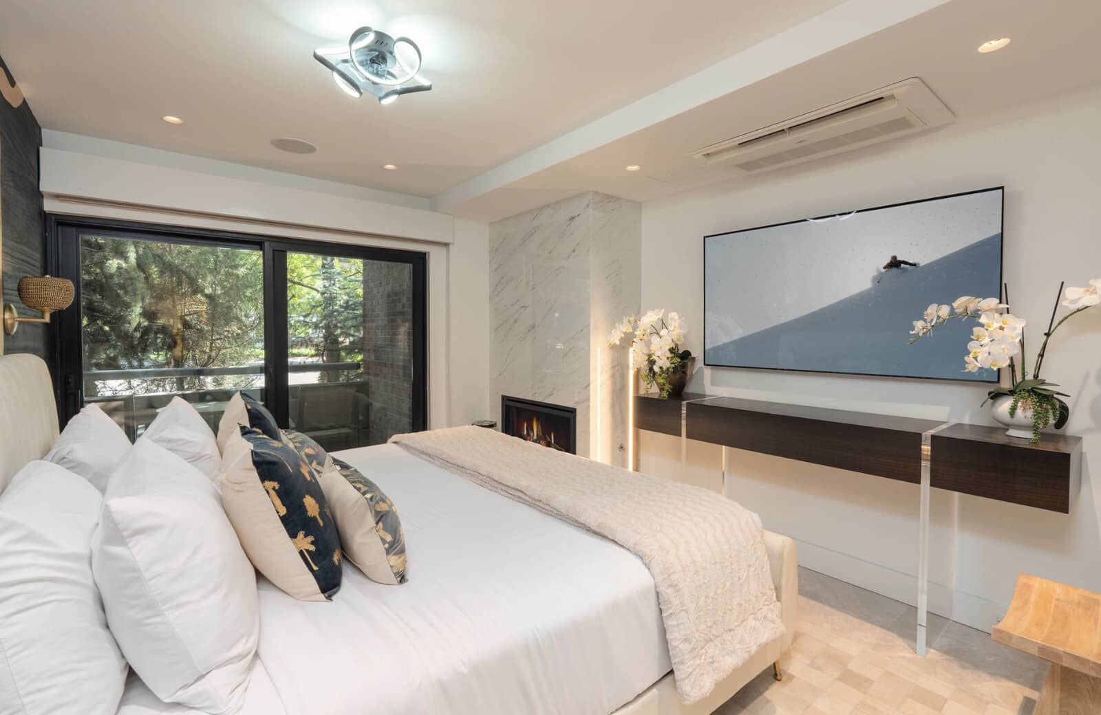 Primary bedroom with king bed, gas fireplace, and balcony access