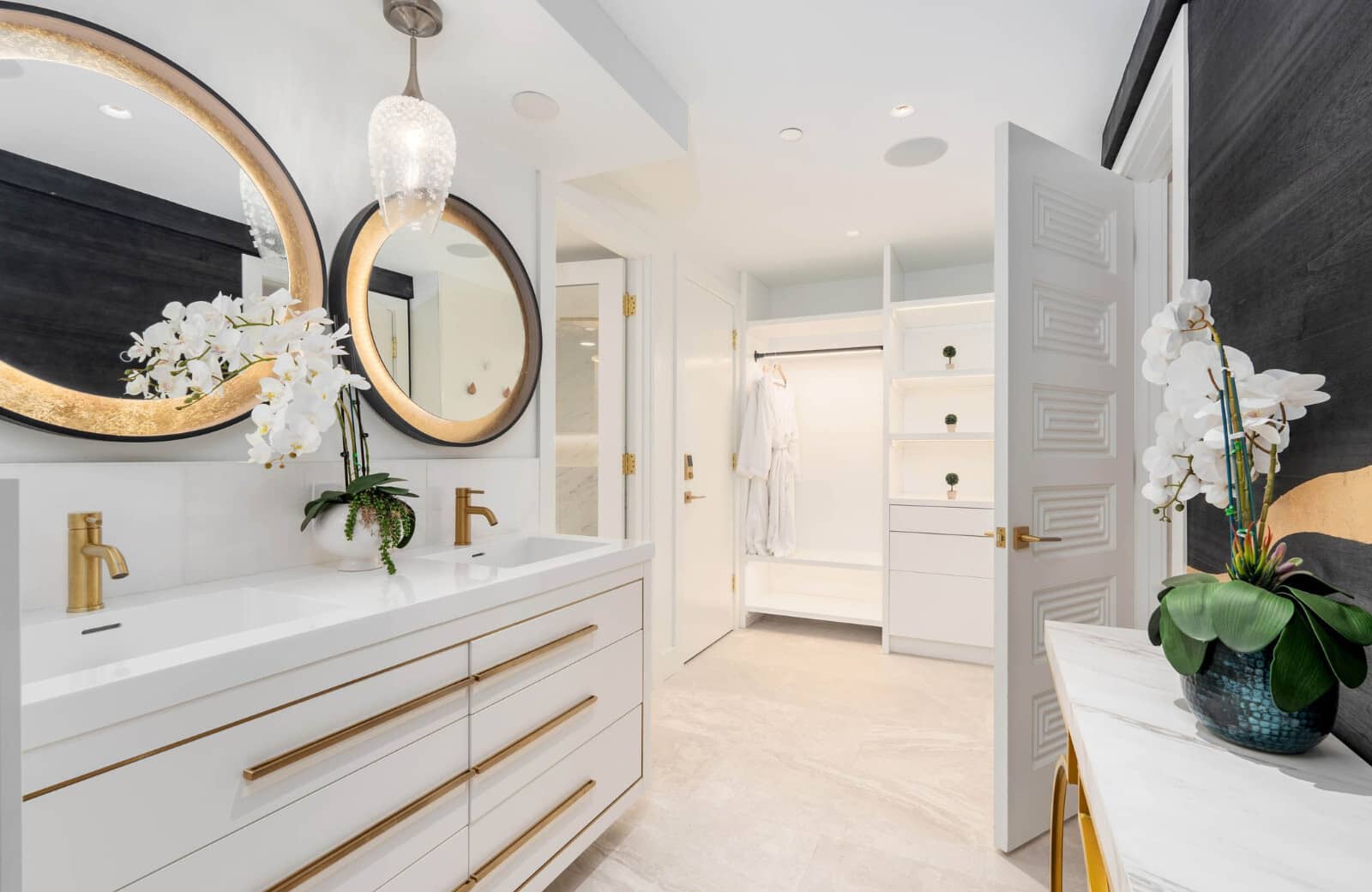 Dual vanity with gold fixtures and walk-in closet