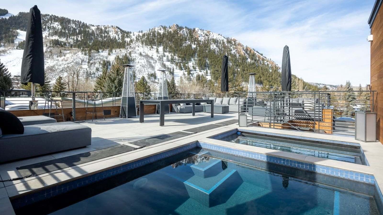 Rooftop terrace with heated pool, hot tub, and mountain views
