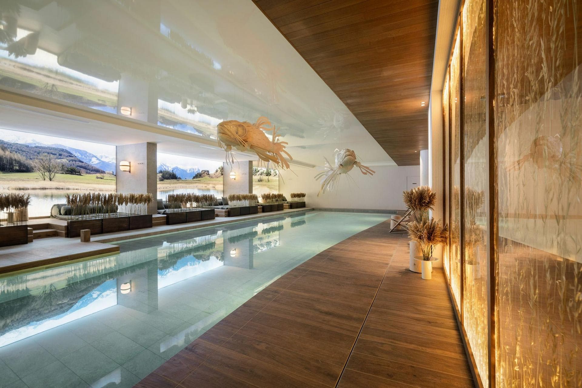 Indoor lap pool with floor-to-ceiling mountain and lake views