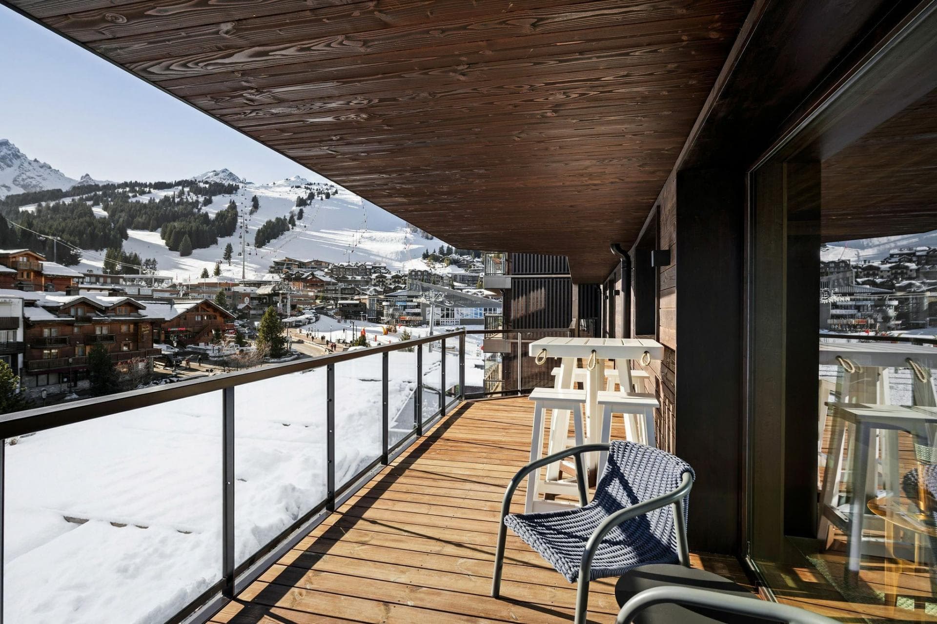 Covered balcony with high-top seating and direct ski slope views