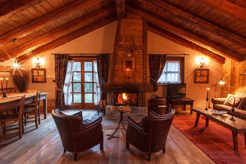 Open-plan living area with wood-burning fireplace and vaulted timber ceilings