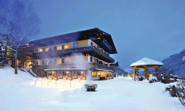 Chalet exterior with heated terrace, fire pit, and mountain valley views