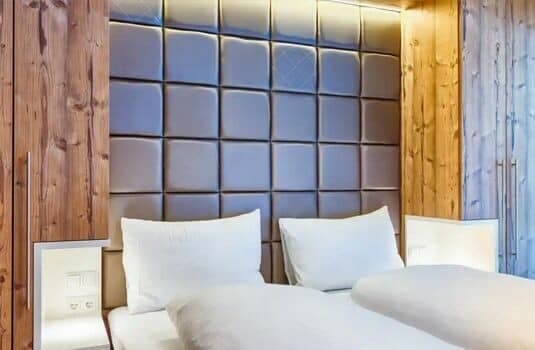 Bedroom with padded headboard, integrated reading lights, and bedside power outlets