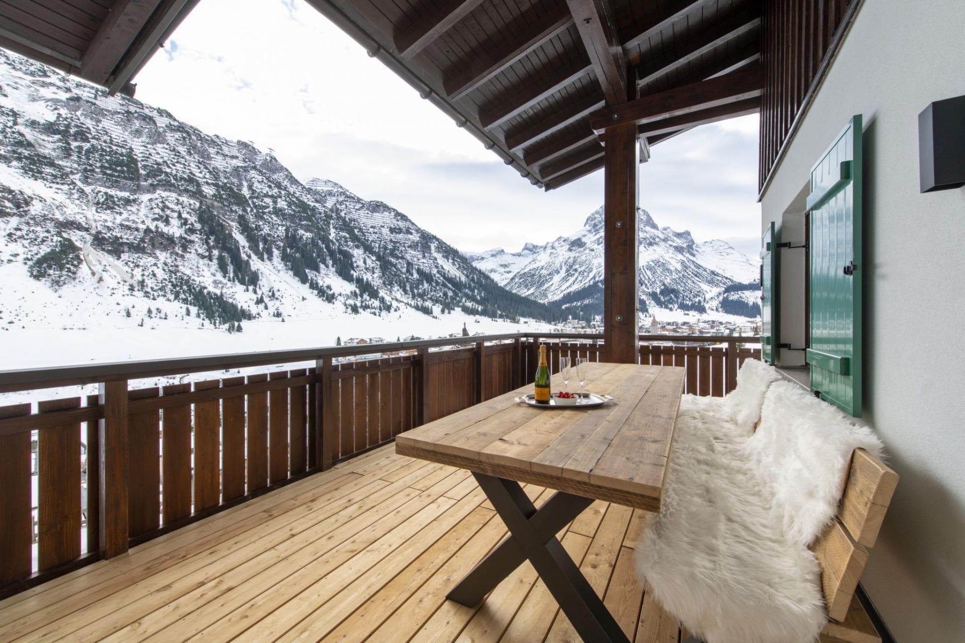 Covered balcony with wooden dining table and panoramic mountain views