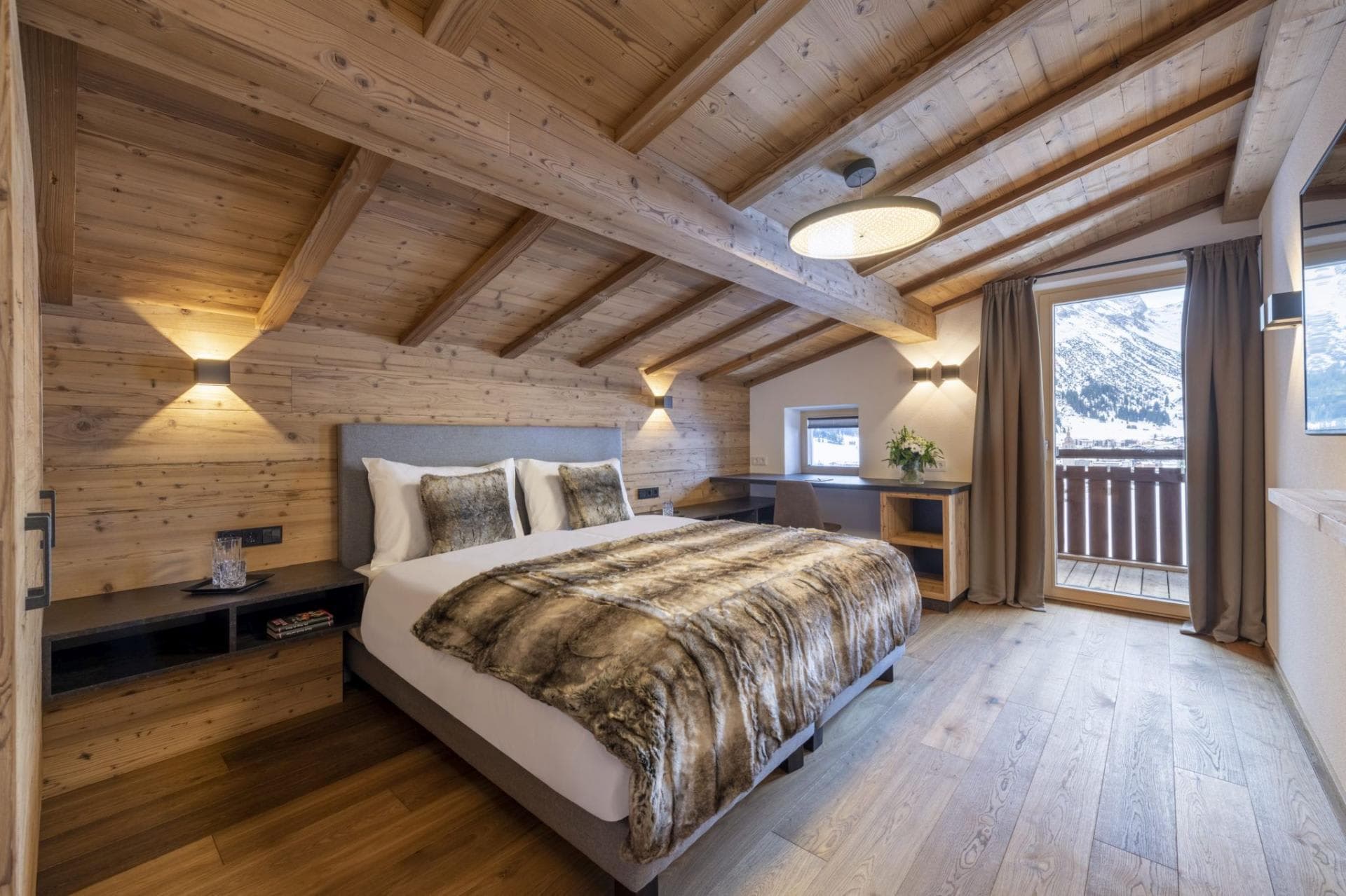 Bedroom with king bed, integrated desk, and mountain-view balcony