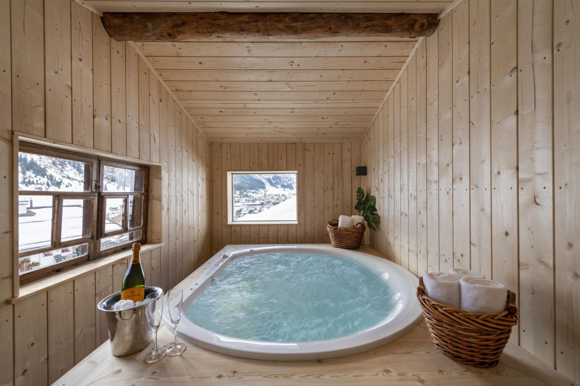 Indoor hot tub with mountain village views and light wood paneling