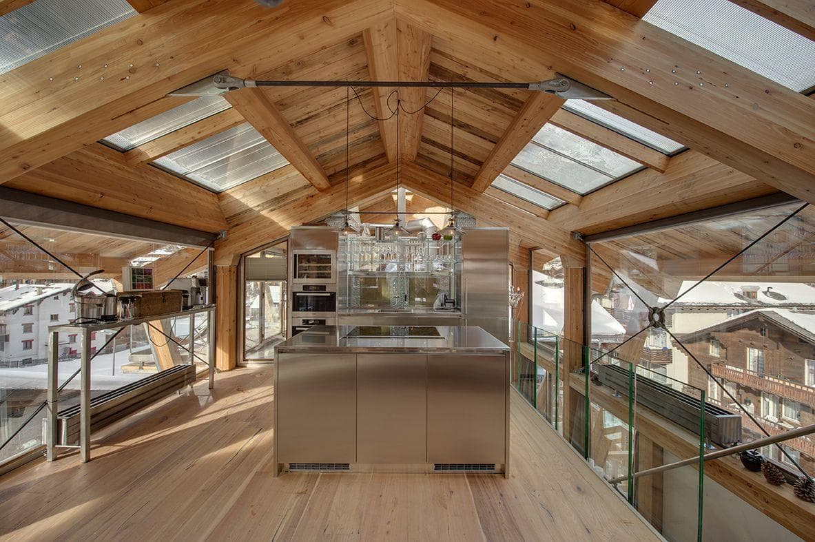 Top-floor kitchen with stainless steel island, wine fridge, and skylights