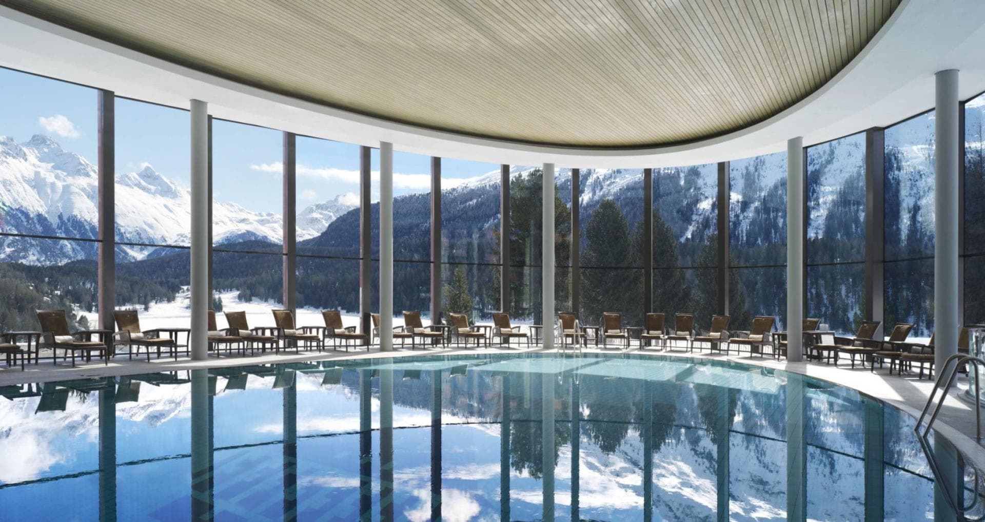 Indoor pool with floor-to-ceiling windows and panoramic alpine views