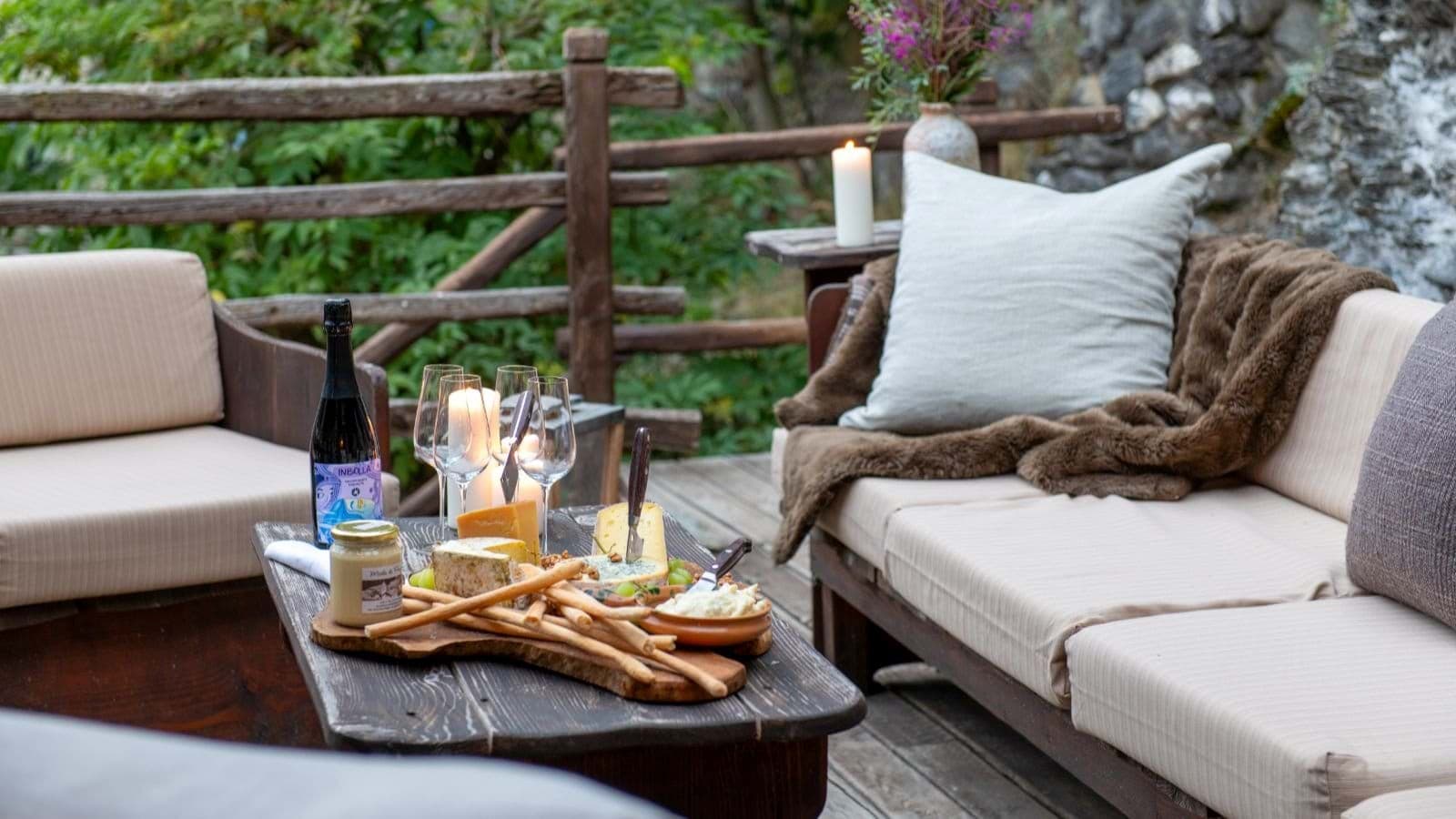 Private wood deck with cushioned lounge seating and rustic coffee table