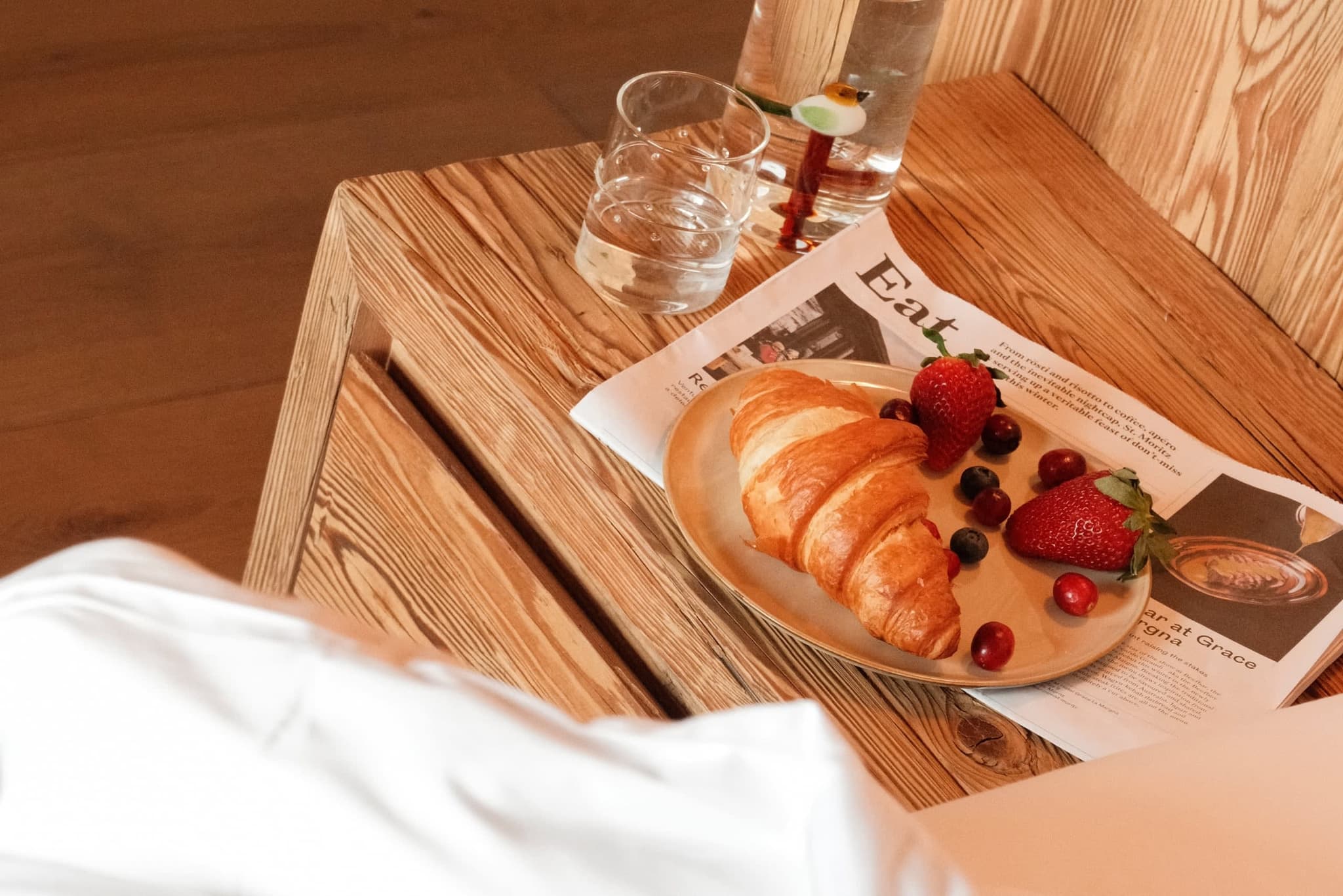 Natural wood bedside table and headboard detail