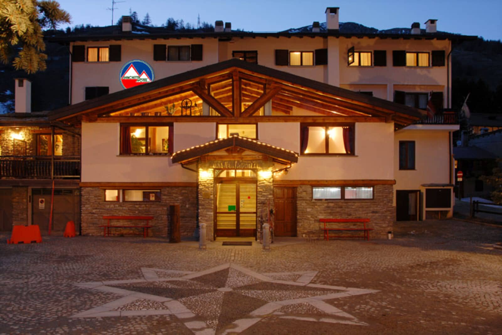 Chalet entrance with stone-paved courtyard and exposed timber beams