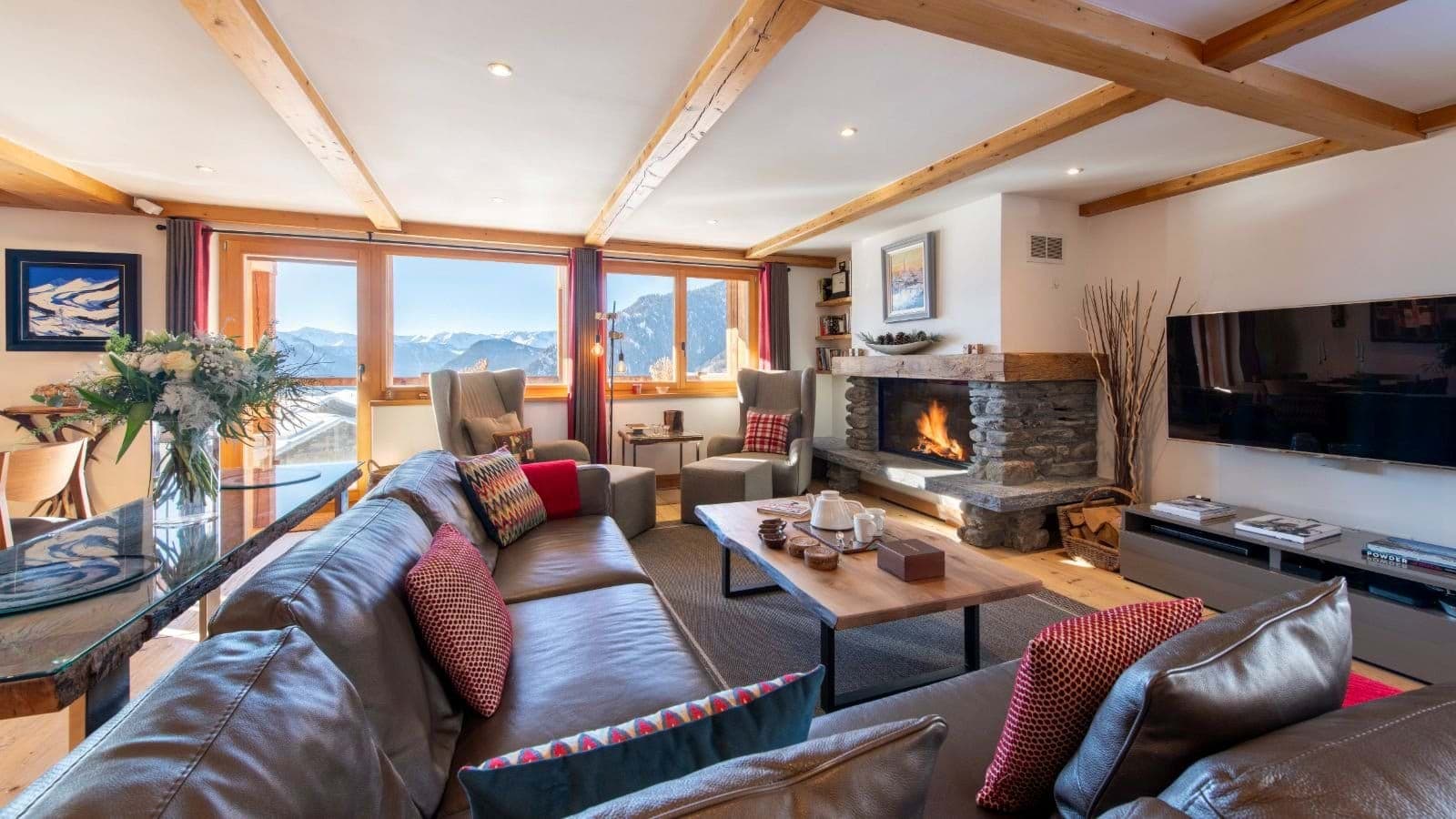 Living area with wood-burning fireplace and mountain-view balcony access