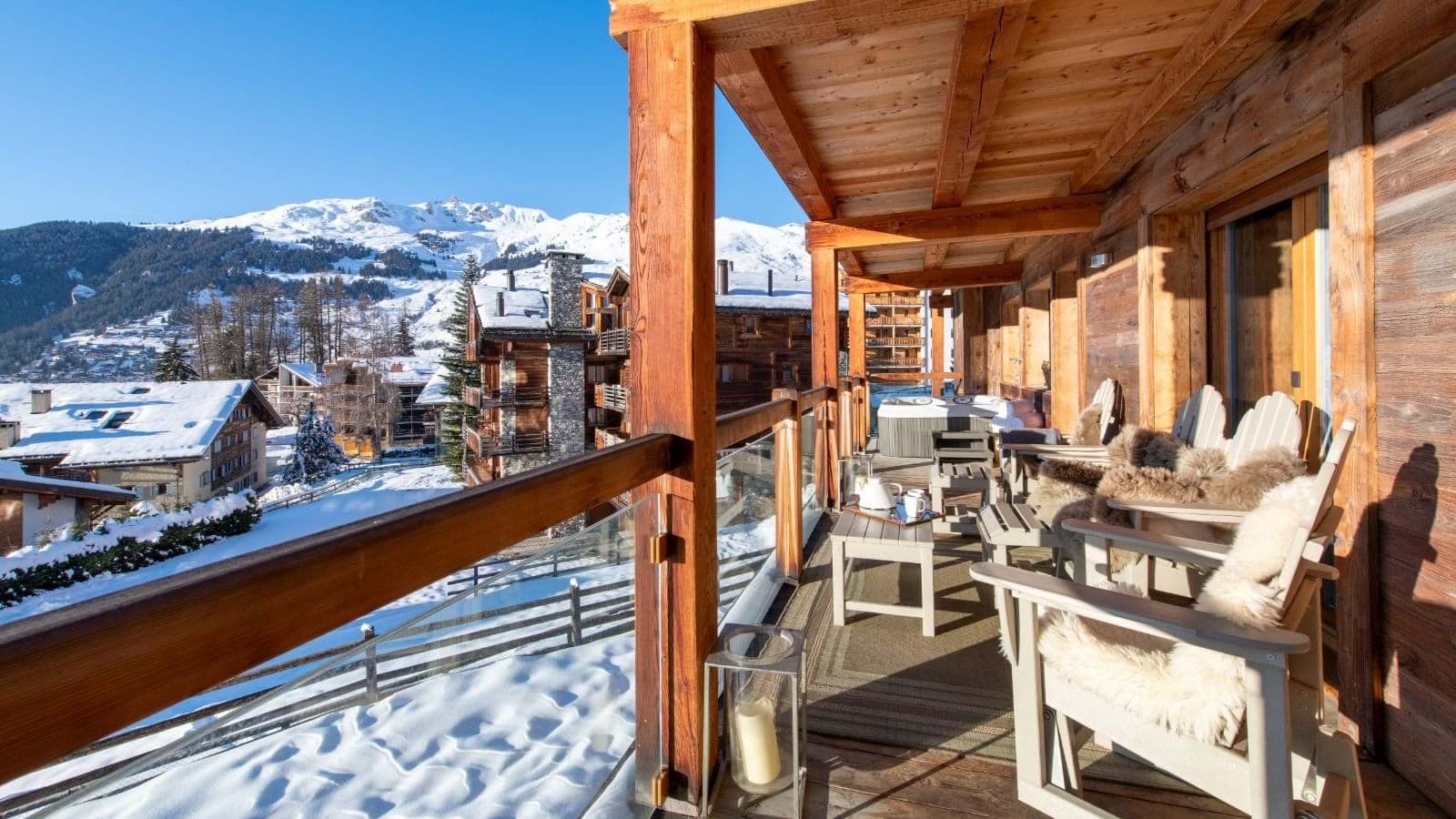 Covered balcony with heated hot tub and alpine mountain views