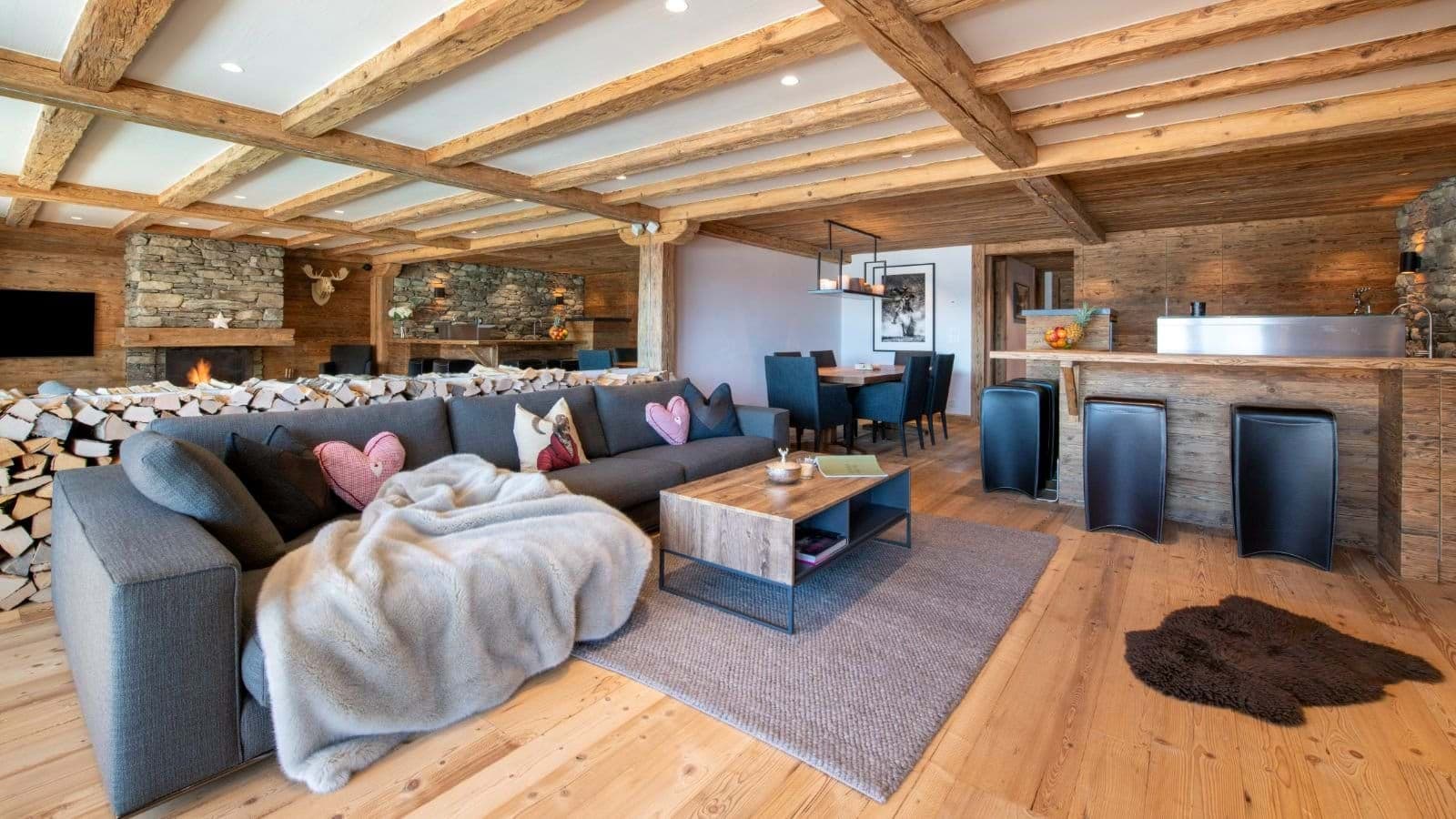 Open-plan living area with wood-beam ceilings and wood-burning fireplace