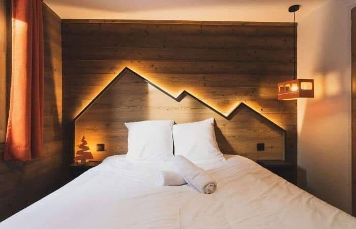 Guest bedroom with queen bed and custom backlit mountain headboard
