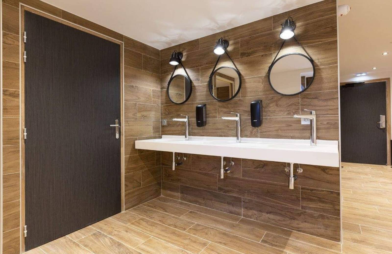 Shared washroom with triple vanity and wood-look porcelain tiling