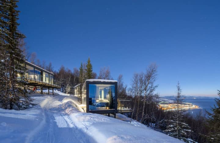 Cantilevered cabins with floor-to-ceiling windows and fjord views