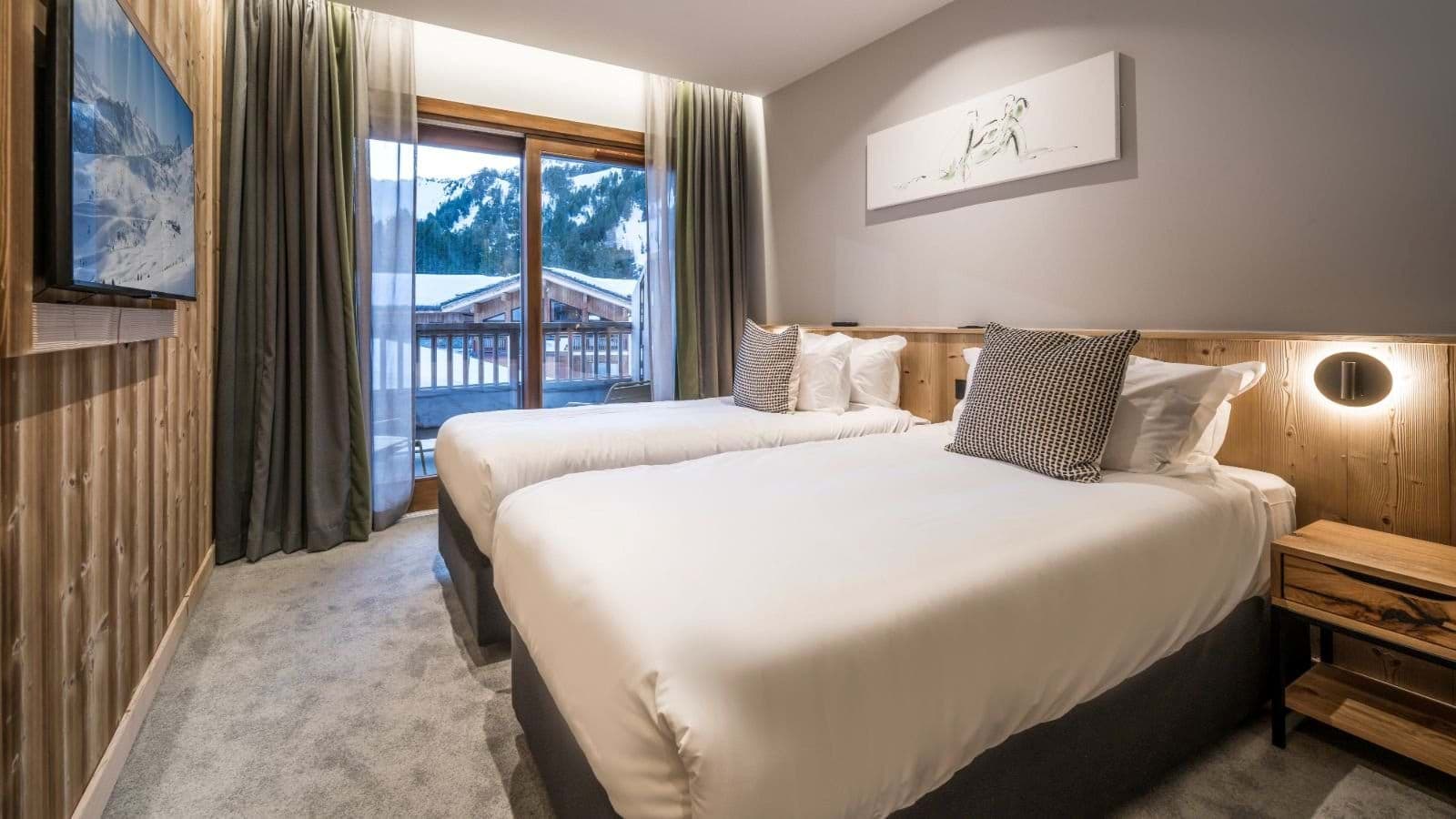 Guest bedroom with two twin beds and private balcony access