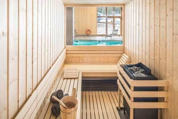 Private sauna with window overlooking indoor pool and snowy outdoors