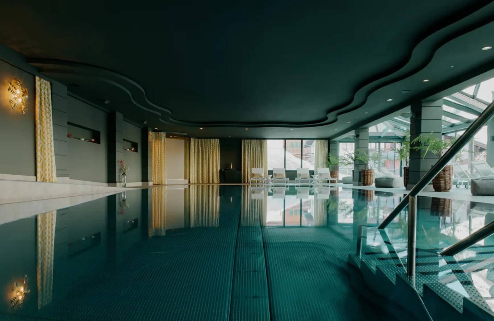 Indoor pool with loungers and glass atrium roof access