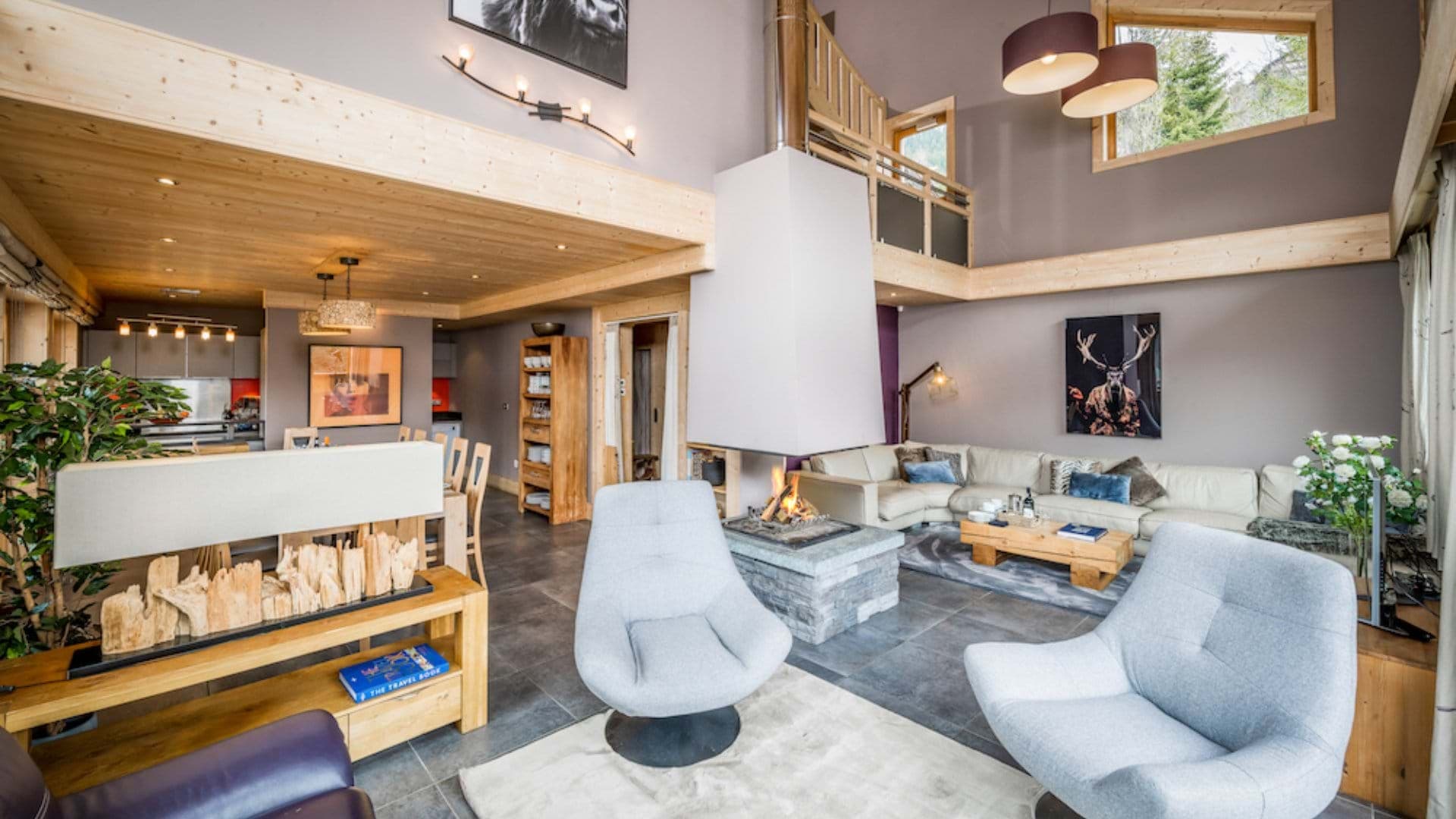 Open-plan living area with 360-degree central fireplace and mezzanine overlook