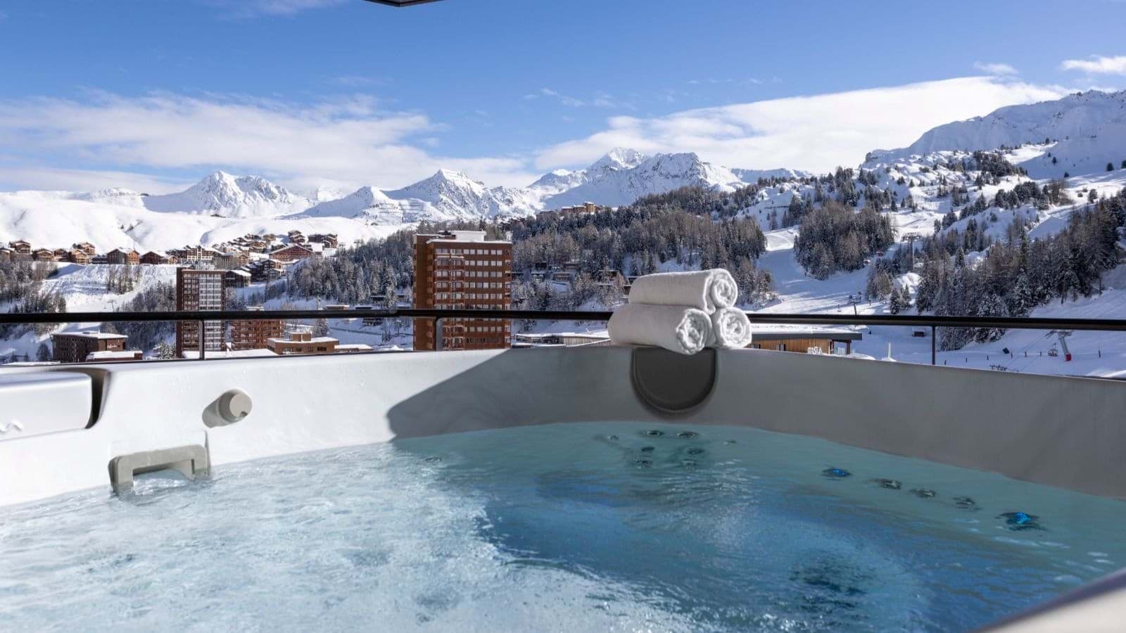 Outdoor hot tub with views of mountain peaks and ski slopes