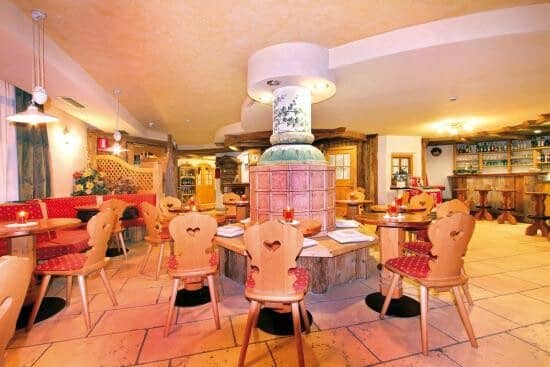 Dining area with heart-cutout wooden chairs and background bar