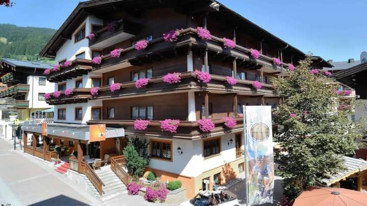Chalet-style exterior with flower-filled balconies and outdoor dining area
