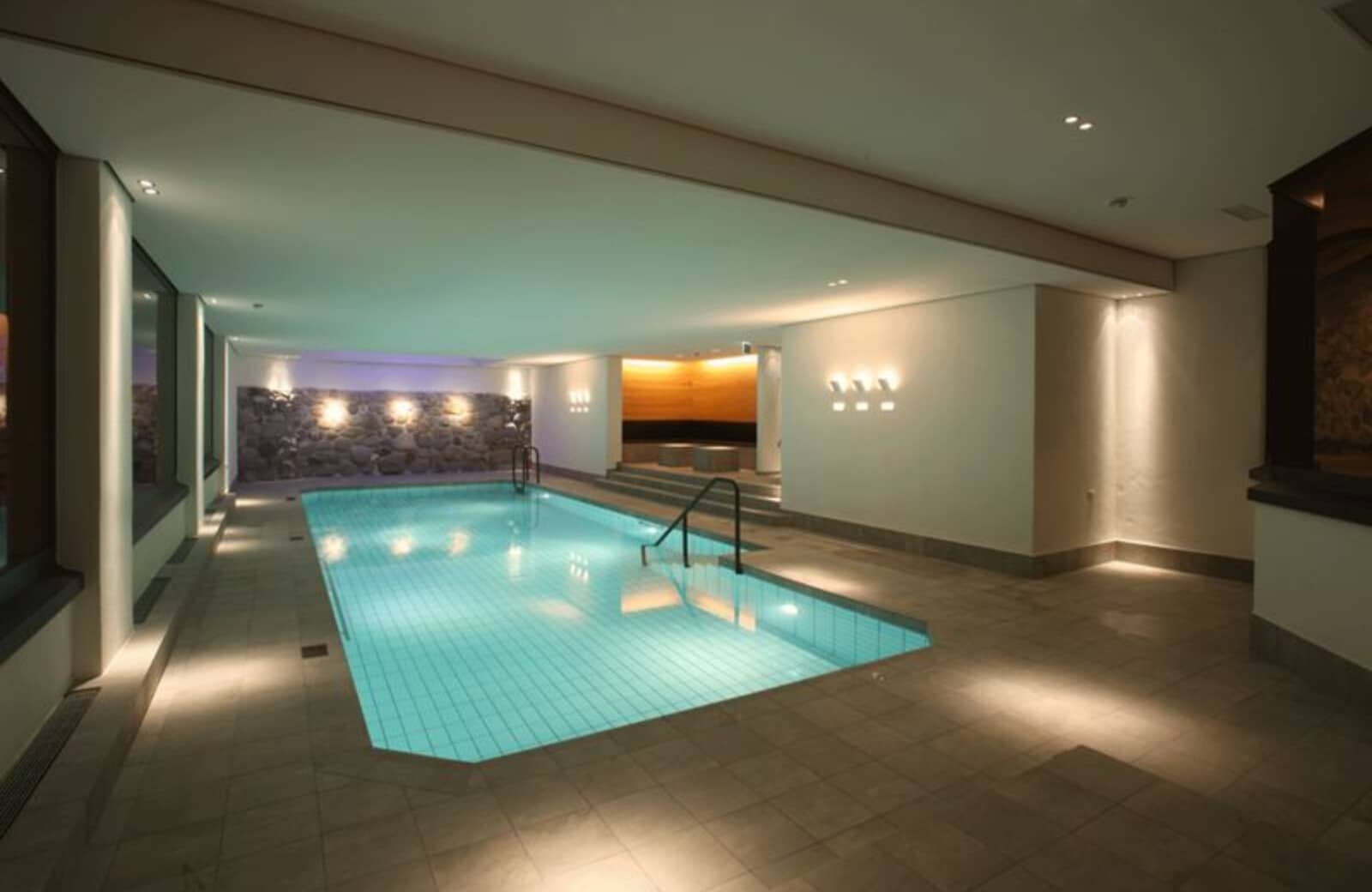 Indoor pool with integrated steps and adjacent sauna area