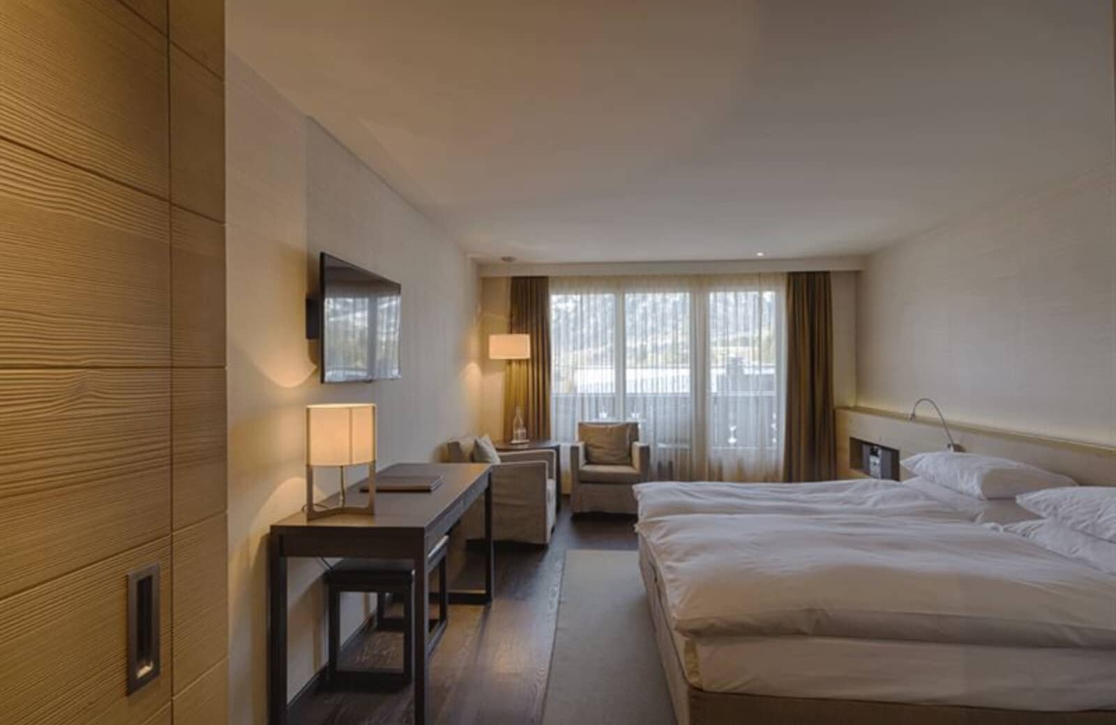 Bedroom with king bed, dedicated workspace, and armchair seating