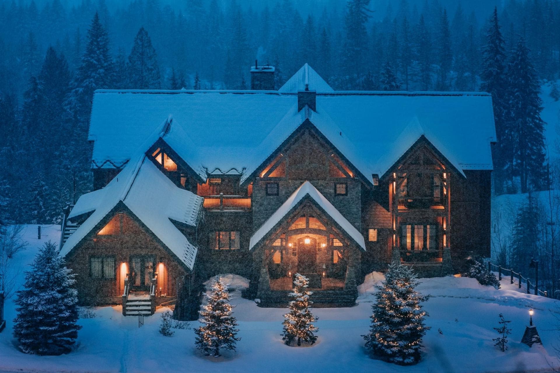 Stone lodge exterior with timber gables and heated entryway stairs