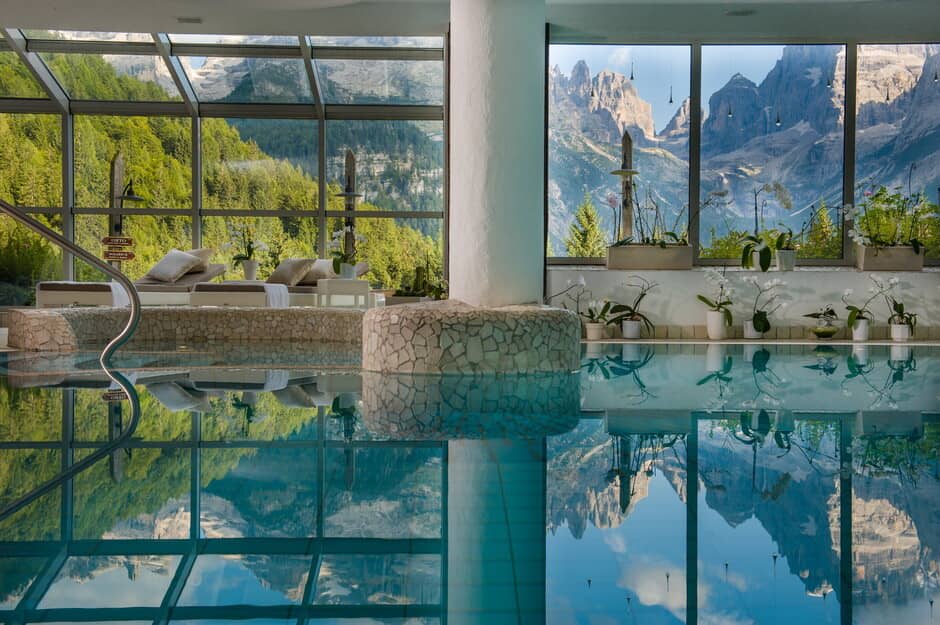 Indoor pool area with solarium lounge and Dolomite mountain views
