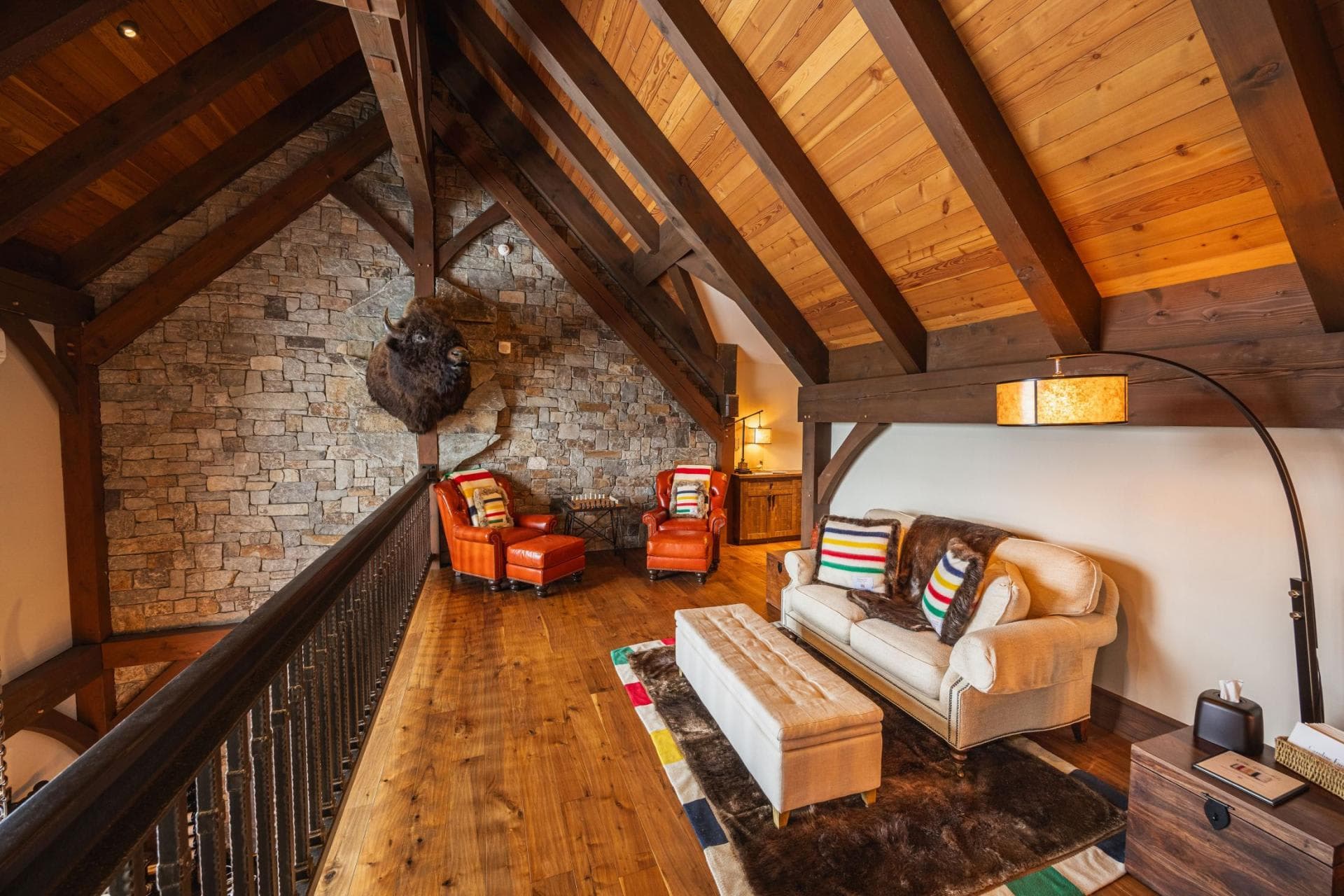 Loft seating area with vaulted timber ceilings and stone feature wall