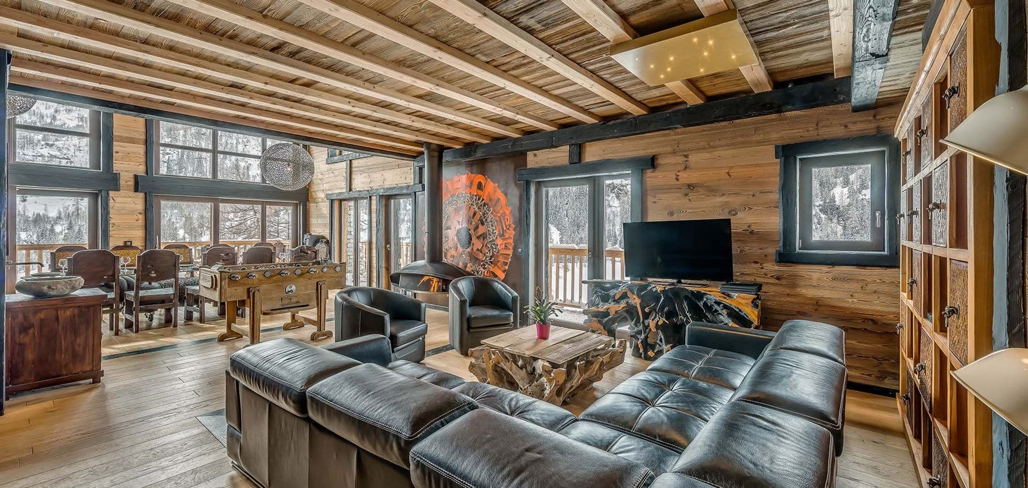 Open living area with wood-burning fireplace, foosball table, and mountain views