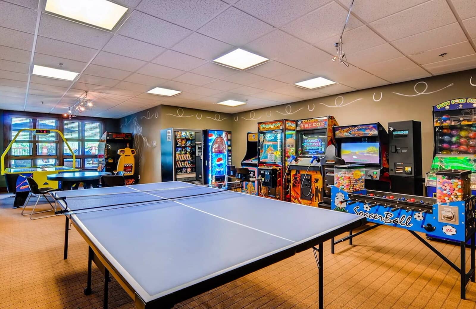 Game room with ping pong, foosball, arcade cabinets, and vending machines