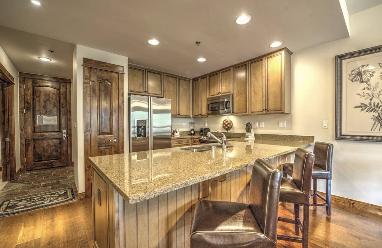 Kitchen with granite island seating for 3 and stainless steel appliances
