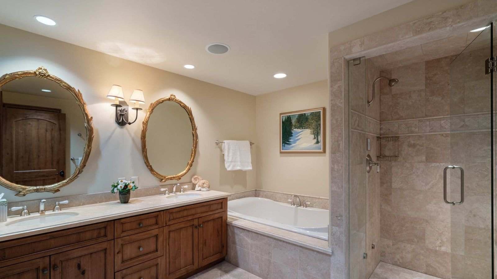 Bathroom with dual vanity, soaking tub, and glass-enclosed walk-in shower