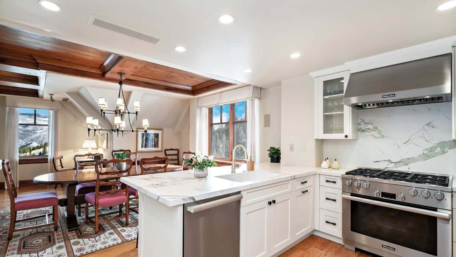 Kitchen with Miele appliances and marble island; adjacent dining area seats 8
