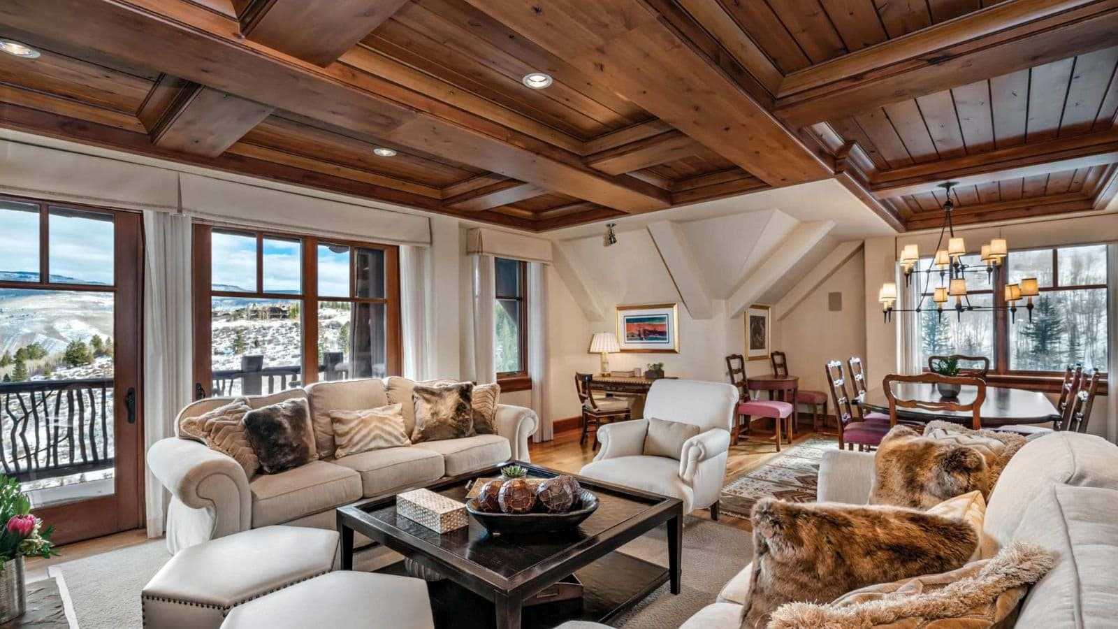 Living area with coffered wood ceilings and valley views from private balcony