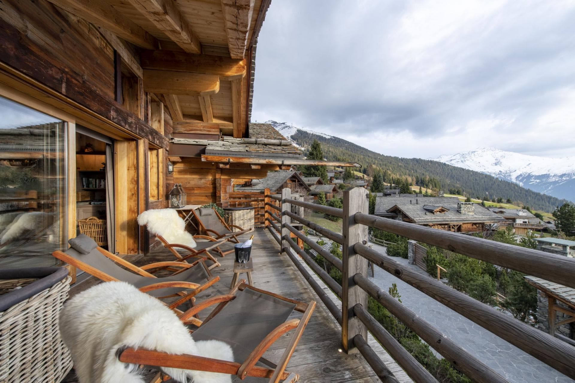 Wood-decked balcony with lounge chairs and panoramic mountain views