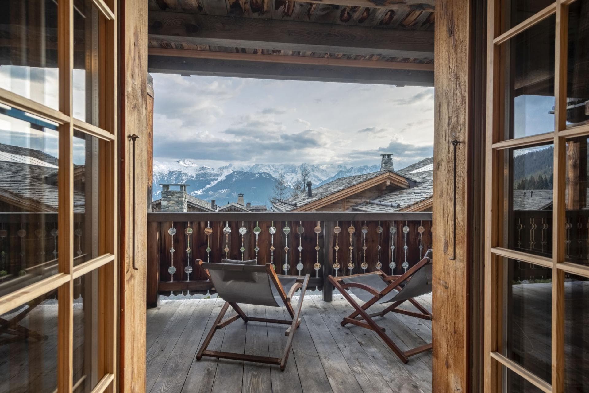 Private balcony with lounge seating and snow-capped mountain views