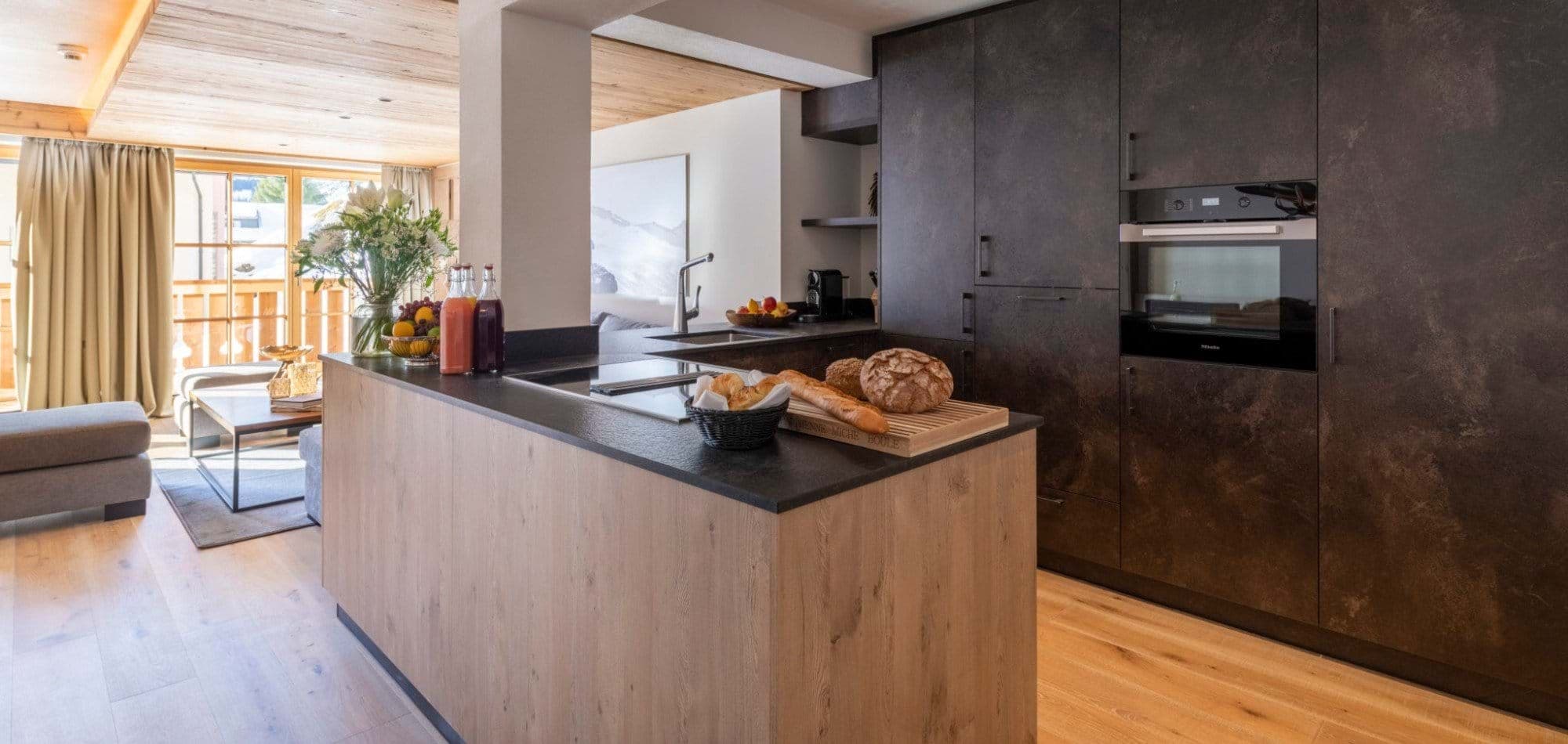 Open-plan kitchen with induction cooktop and integrated wall oven