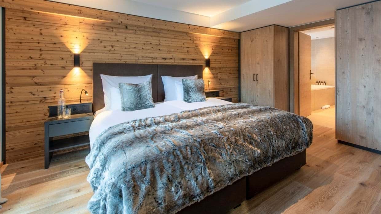 King bedroom with wood paneling and ensuite bathroom with soaking tub