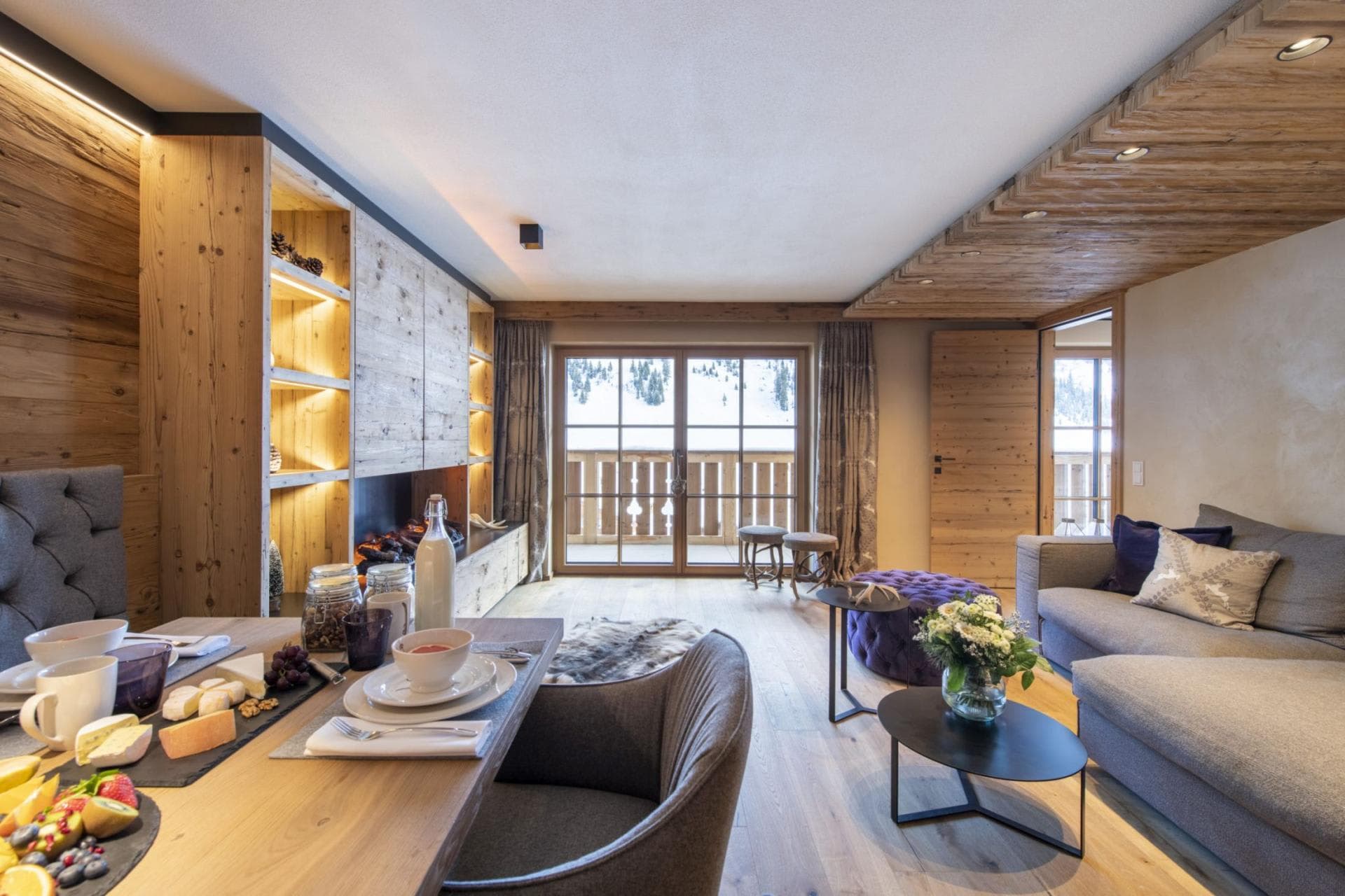 Open-plan living area with electric fireplace and private balcony access