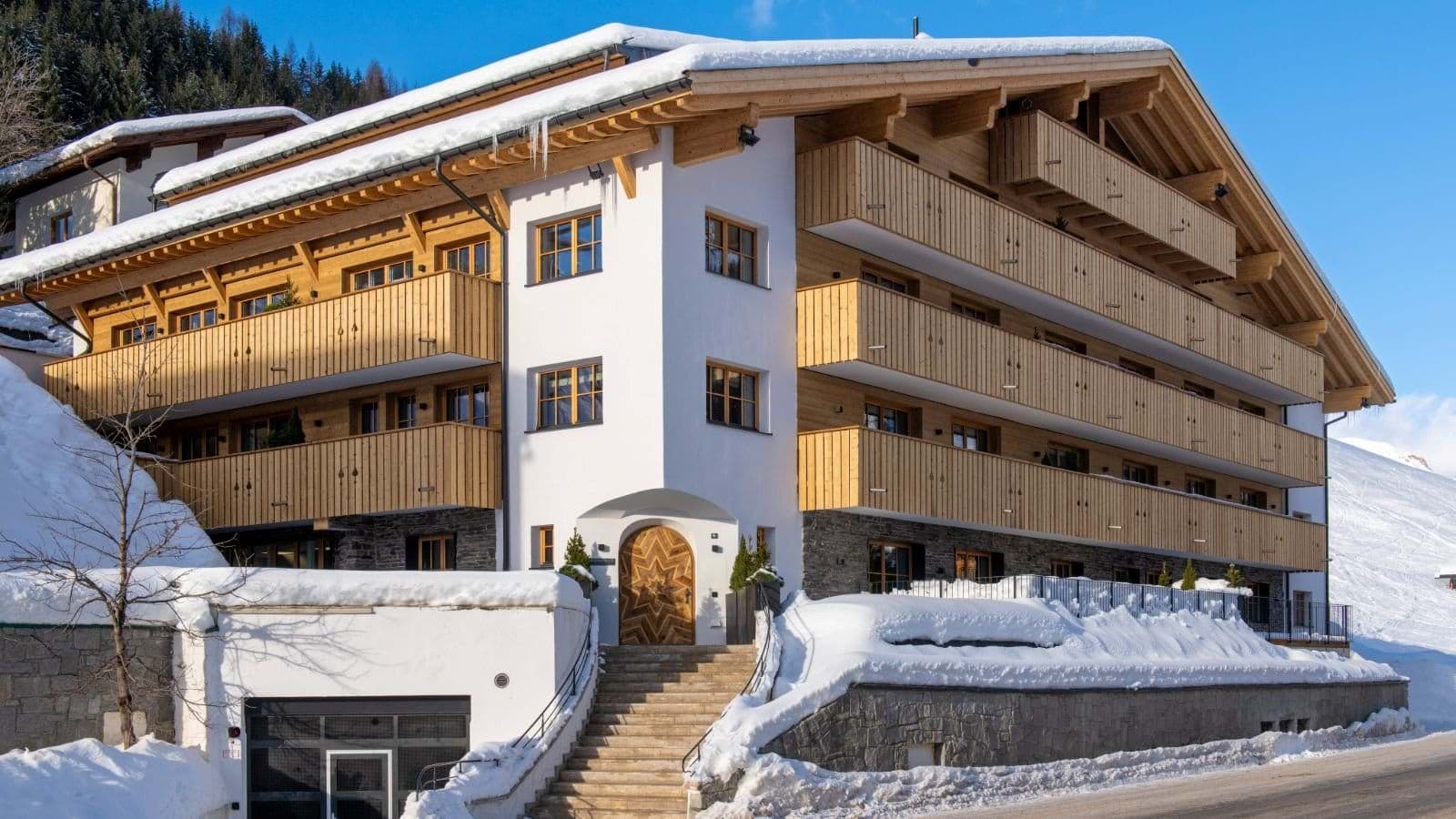 Chalet exterior featuring private timber balconies and street-level garage parking