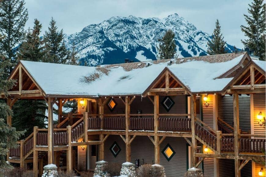 Timber-framed lodge exterior with private balconies and mountain backdrop