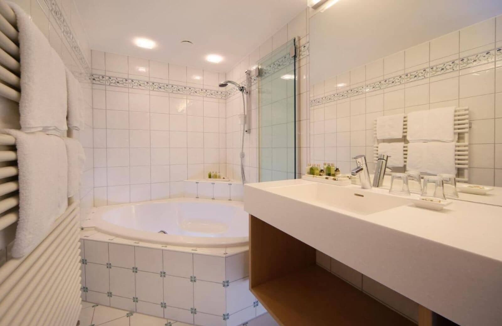 Bathroom with soaking tub, vanity, and heated towel rack