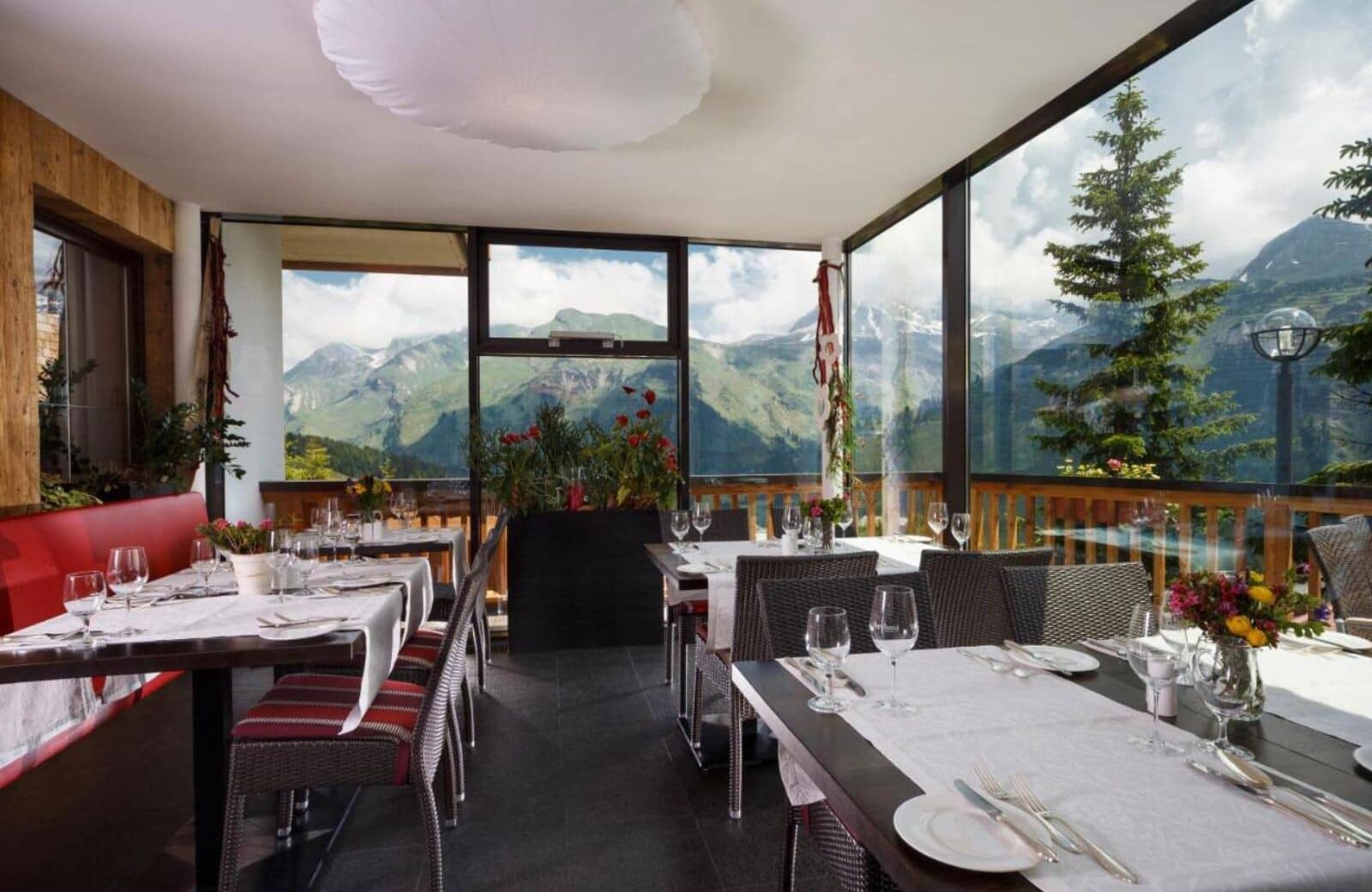 Enclosed sunroom dining area with floor-to-ceiling mountain views